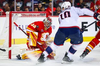 Nov 5, 2025; Calgary, Alberta, CAN; Calgary Flames goaltender Dustin Wolf (32) makes a save against Columbus Blue Jackets left wing Dmitri Voronkov (10) during the third period at Scotiabank Saddledome. Mandatory Credit: Sergei Belski-Imagn Images