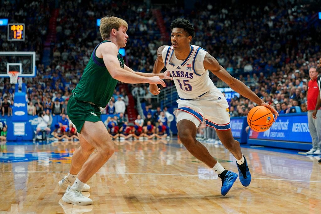 Nov 3, 2025; Lawrence, Kansas, USA; Kansas Jayhawks forward Bryson Tiller (15) drives against Green Bay Phoenix guard Keegan van Kauwenberg (3) during the second half at Allen Fieldhouse. Mandatory Credit: Jay Biggerstaff-Imagn Images