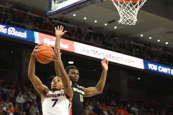 Nov 11, 2025; Auburn, Alabama, USA;  Auburn Tigers guard Keyshawn Hall (7) grabs a rebound from Wofford Terriers guard Kahmare Holmes (11) during the first half at Neville Arena. Mandatory Credit: John Reed-Imagn Images