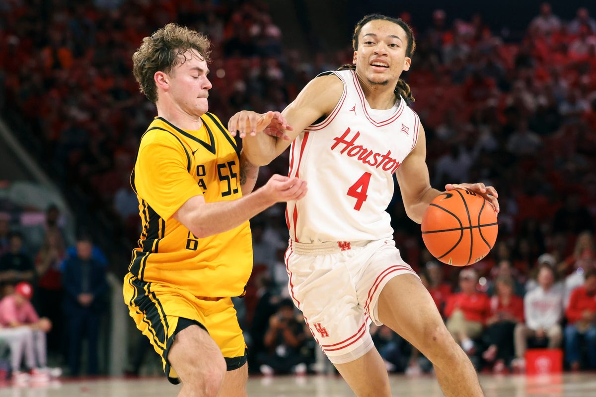 Nov 12, 2025; Houston, Texas, USA; Houston Cougars guard Kingston Flemings (4) drives with the ball as Oakland Golden Grizzlies guard Brody Robinson (55) defends during the first half at Fertitta Center. Mandatory Credit: Troy Taormina-Imagn Images