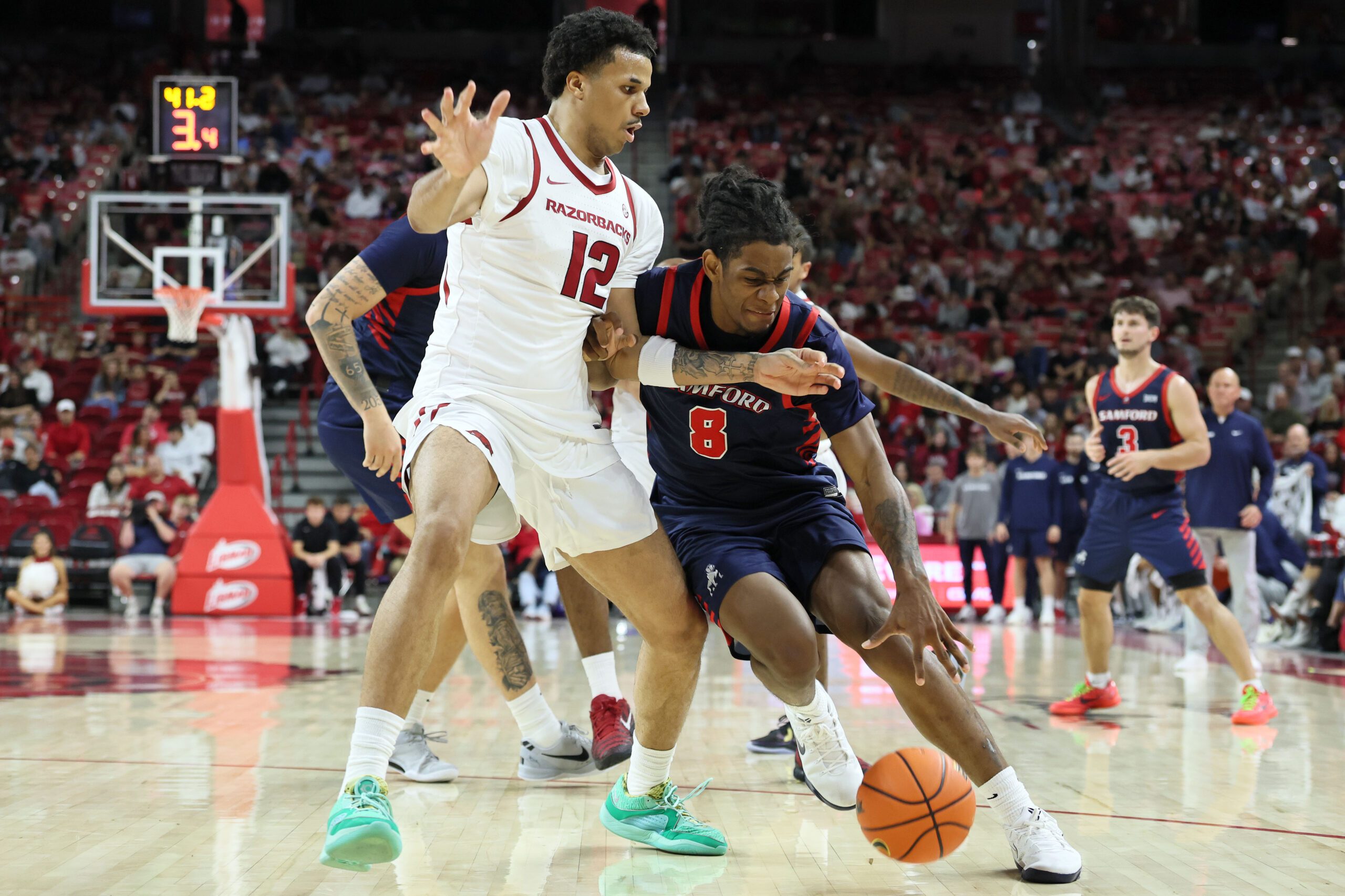 Nov 14, 2025; Fayetteville, Arkansas, USA; Samford Bulldogs guard Zion Wilburn (8) drives against Arkansas Razorbacks forward Malique Ewin (12) during the first half at Bud Walton Arena. Mandatory Credit: Nelson Chenault-Imagn Images