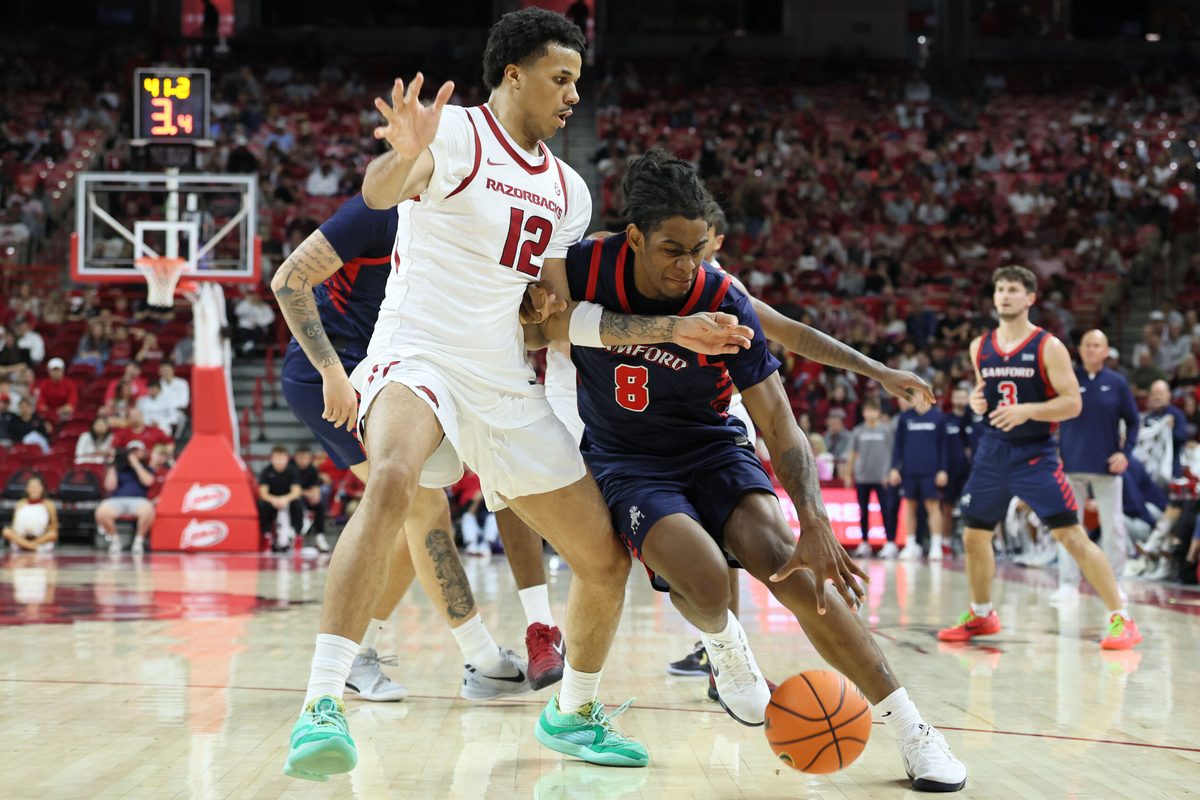 Nov 14, 2025; Fayetteville, Arkansas, USA; Samford Bulldogs guard Zion Wilburn (8) drives against Arkansas Razorbacks forward Malique Ewin (12) during the first half at Bud Walton Arena. Mandatory Credit: Nelson Chenault-Imagn Images