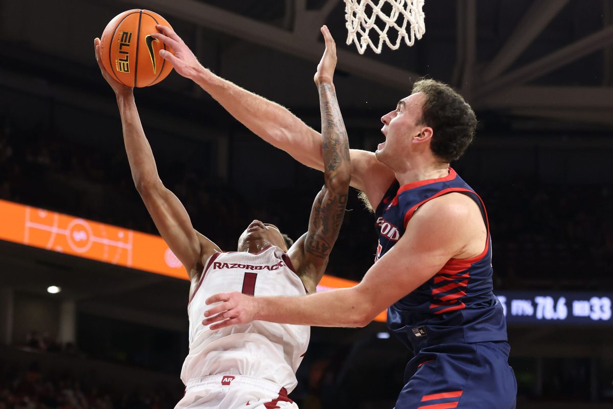Nov 14, 2025; Fayetteville, Arkansas, USA; Arkansas Razorbacks guard Meleek Thomas (1) is fouled while shooting by Samford Bulldogs forward Dylan Faulkner (15) during the second half at Bud Walton Arena. Arkansas won 79-75. Mandatory Credit: Nelson Chenault-Imagn Images