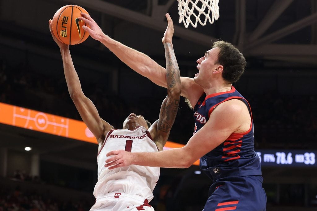 Nov 14, 2025; Fayetteville, Arkansas, USA; Arkansas Razorbacks guard Meleek Thomas (1) is fouled while shooting by Samford Bulldogs forward Dylan Faulkner (15) during the second half at Bud Walton Arena. Arkansas won 79-75. Mandatory Credit: Nelson Chenault-Imagn Images