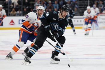 Nov 14, 2025; Salt Lake City, Utah, USA; Utah Mammoth defenseman Dmitri Simashev (26) controls the puck against New York Islanders left wing Jonathan Drouin (29) during the second period at Delta Center. Mandatory Credit: Rob Gray-Imagn Images