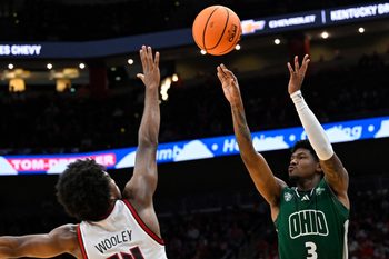 Nov 15, 2025; Louisville, Kentucky, USA;  Ohio Bobcats guard Dior Conners (3) shoots against Louisville Cardinals guard Adrian Wooley (14) during the first half at KFC Yum! Center. Mandatory Credit: Jamie Rhodes-Imagn Images