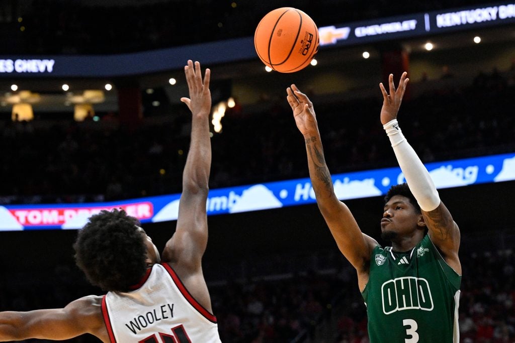 Nov 15, 2025; Louisville, Kentucky, USA; Ohio Bobcats guard Dior Conners (3) shoots against Louisville Cardinals guard Adrian Wooley (14) during the first half at KFC Yum! Center. Mandatory Credit: Jamie Rhodes-Imagn Images
