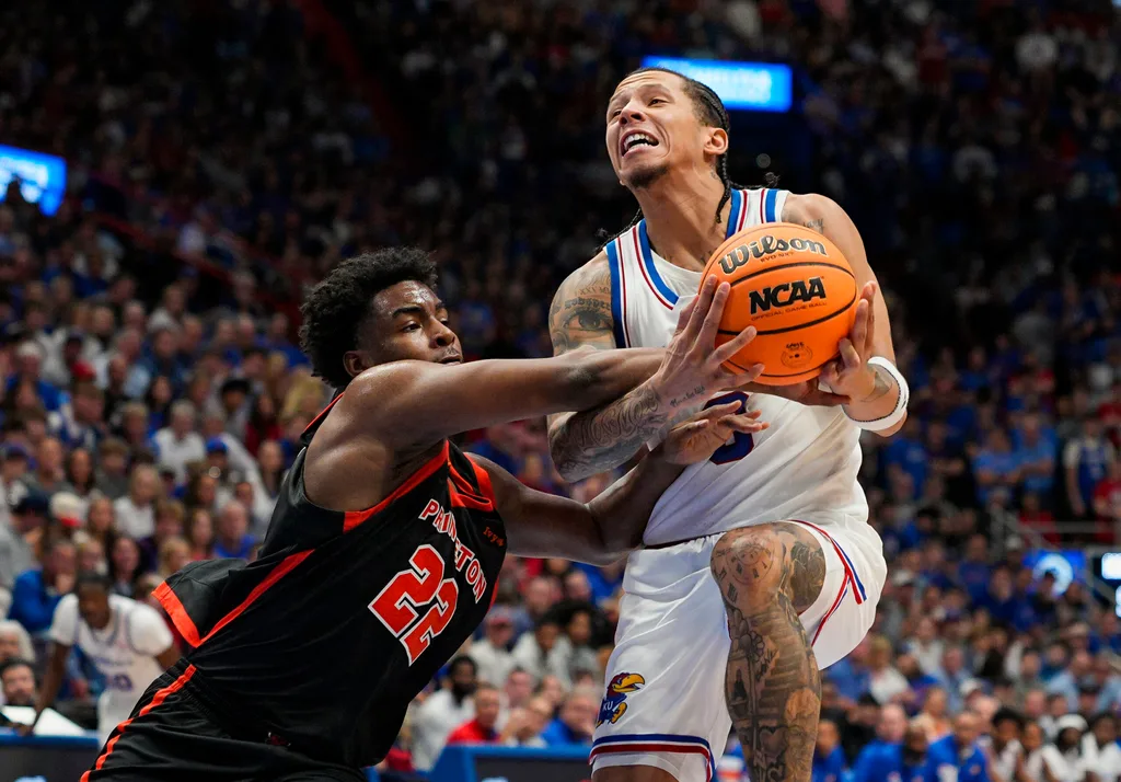 Nov 15, 2025; Lawrence, Kansas, USA; Kansas Jayhawks guard Tre White (3) is fouled while shooting against Princeton Tigers guard Dalen Davis (22) during the first half at Allen Fieldhouse. Mandatory Credit: Jay Biggerstaff-Imagn Images
