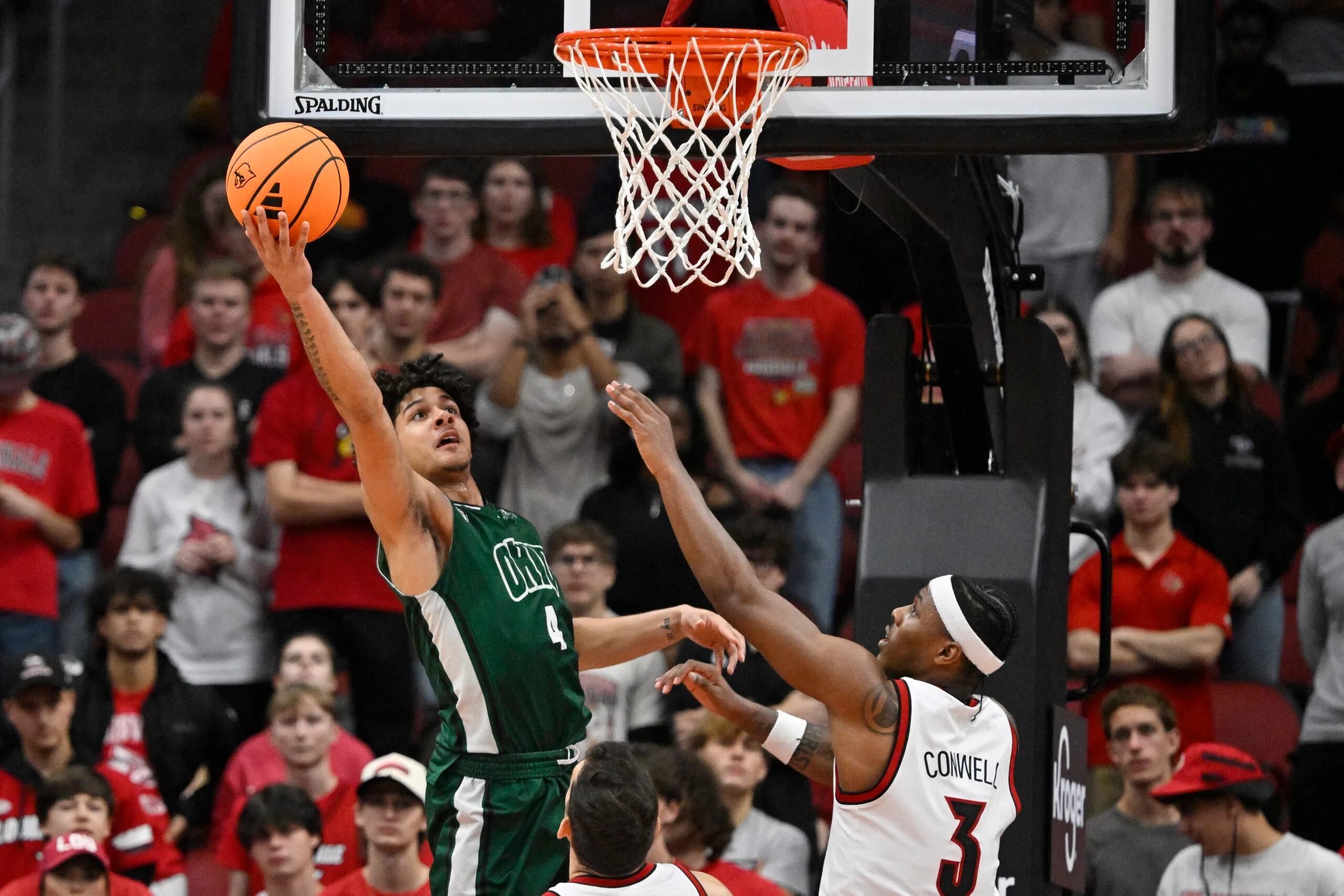 Nov 15, 2025; Louisville, Kentucky, USA;  Ohio Bobcats guard JJ Kelly (4) shoots against Louisville Cardinals guard Ryan Conwell (3) during the second half at KFC Yum! Center. Louisville defeated Ohio 106-81. Mandatory Credit: Jamie Rhodes-Imagn Images