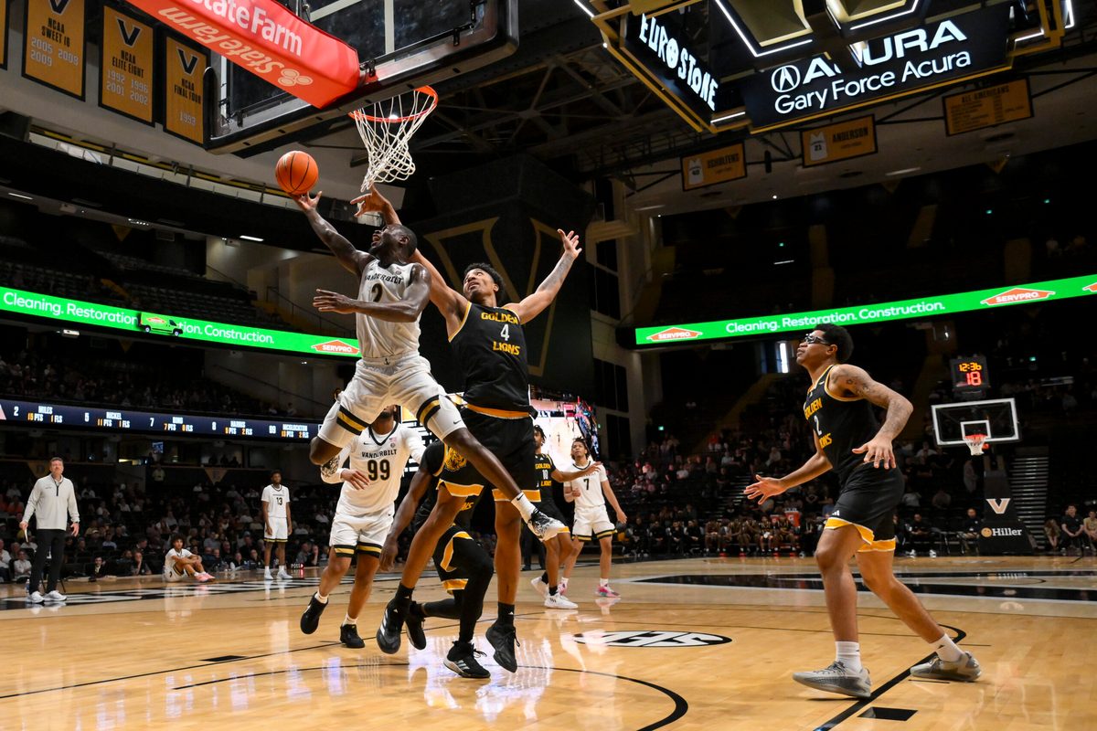 Nov 15, 2025; Nashville, Tennessee, USA; Vanderbilt Commodores guard Duke Miles (2) goes under the arms of Arkansas-Pine Bluff Golden Lions forward Jaquan Scott (4) during the second half at Memorial Gymnasium. Mandatory Credit: Steve Roberts-Imagn Images