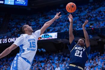 Nov 18, 2025; Chapel Hill, North Carolina, USA; Navy Midshipmen guard Jordan Pennick (21) shoots over North Carolina Tar Heels forward Jarin Stevenson (15) during the first half at Dean E. Smith Center. Mandatory Credit: Scott Kinser-Imagn Images