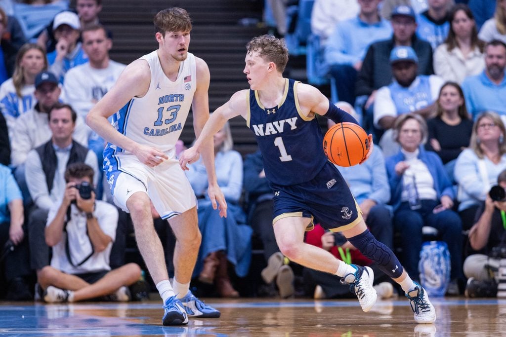 Nov 18, 2025; Chapel Hill, North Carolina, USA; Navy Midshipmen guard Austin Benigni (1) drives around North Carolina Tar Heels center Henri Veesaar (13) during the second half at Dean E. Smith Center. Mandatory Credit: Scott Kinser-Imagn Images