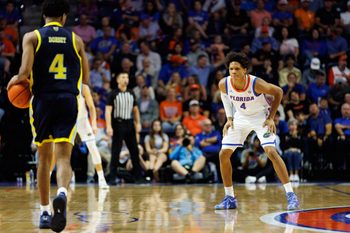 Nov 21, 2025; Gainesville, Florida, USA; Merrimack Warriors guard Tye Dorset (4) dribbles the ball while Florida Gators guard Alex Lloyd (4) defends during the second half at Exactech Arena at the Stephen C. O'Connell Center. Mandatory Credit: Matt Pendleton-Imagn Images