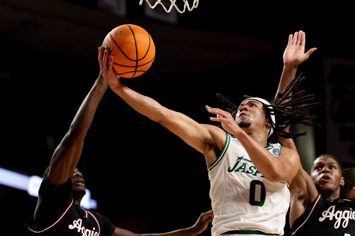 Nov 21, 2025; College Station, Texas, USA; Manhattan Jaspers guard Devin Dinkins (0) goes to the basket as Texas A&M Aggies guard Ali Dibba (6) defends during the second half at Reed Arena. Mandatory Credit: Maria Lysaker-Imagn Images