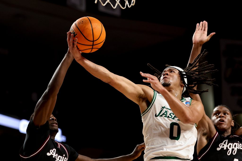 Nov 21, 2025; College Station, Texas, USA; Manhattan Jaspers guard Devin Dinkins (0) goes to the basket as Texas A&M Aggies guard Ali Dibba (6) defends during the second half at Reed Arena. Mandatory Credit: Maria Lysaker-Imagn Images