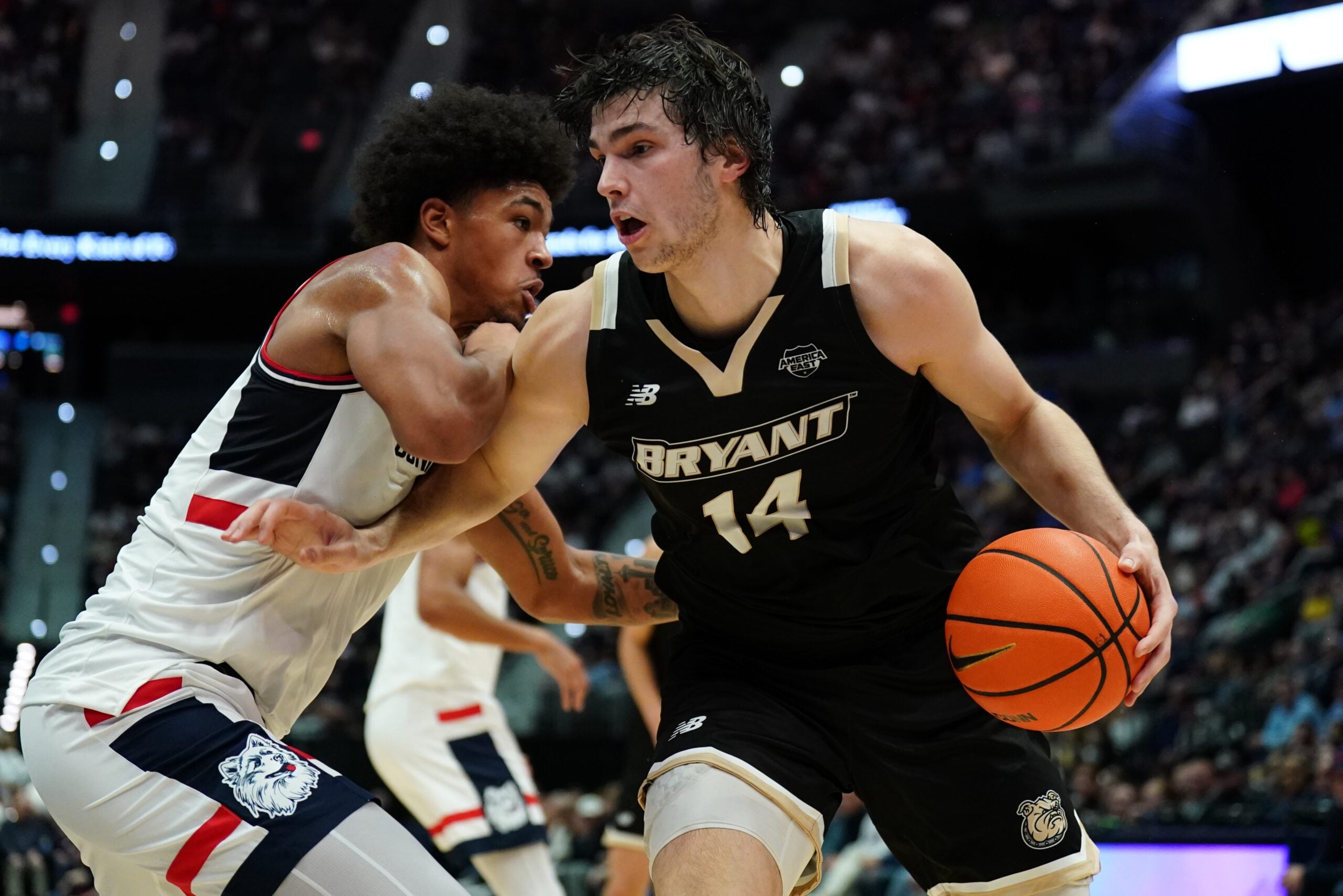 Nov 23, 2025; Hartford, Connecticut, USA; Bryant Bulldogs forward Keegan Harvey (14) drives the ball against UConn Huskies forward Jaylin Stewart (3) in the first half at Peoples Bank Arena. Mandatory Credit: David Butler II-Imagn Images