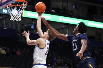 Nov 23, 2025; Pittsburgh, Pennsylvania, USA;  Pittsburgh Panthers guard Nojus Indrusaitis (25) shoots against Quinnipiac Bobcats guard Keith Mcknight (21) during the second half at the Petersen Events Center. Mandatory Credit: Charles LeClaire-Imagn Images