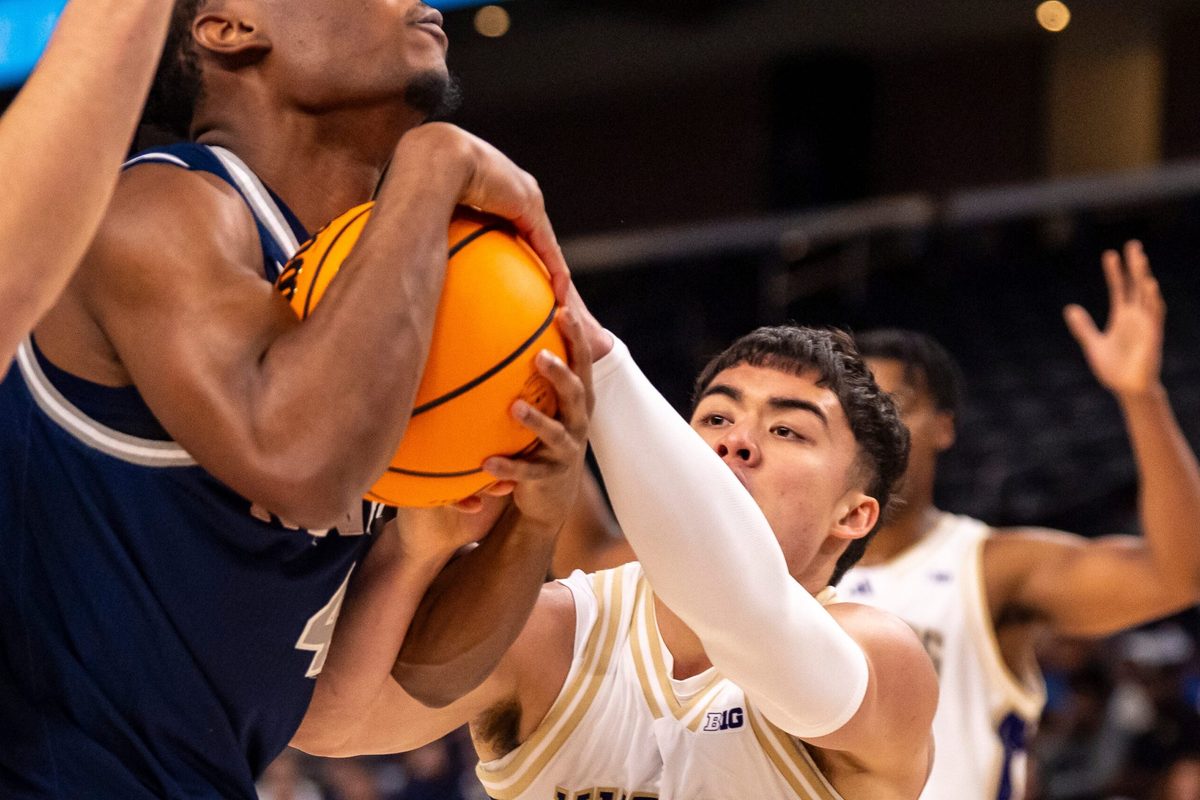 Nevada Wolf Pack guard Corey Camper Jr. (4) fights for a rebound against Washington Huskies guard JJ Mandaquit (23) during the first half of their game in the Acrisure Series in Palm Desert, Calif., Thursday, Nov. 27, 2025.