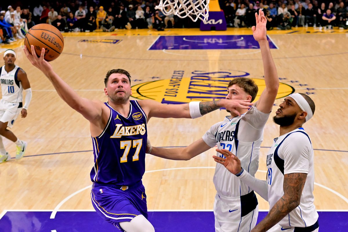 Nov 28, 2025; Los Angeles, California, USA; Los Angeles Lakers guard Luka Doncic (77) drives past Dallas Mavericks forward Cooper Flagg (32) and forward Daniel Gafford (21) in the first half at Crypto.com Arena. Mandatory Credit: Jayne Kamin-Oncea-Imagn Images