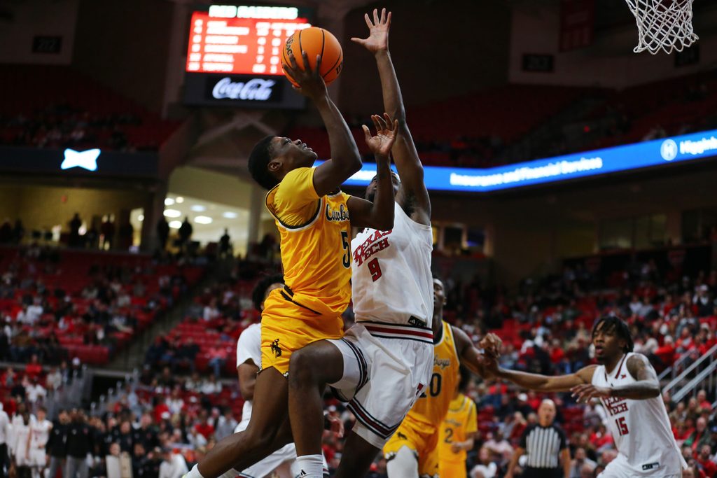 Nov 30, 2025; Lubbock, Texas, USA; Wyoming Cowboys guard Leland Walker (5) goes to the basket against Texas Tech Red Raiders forward Luke Bamgboye (9) in the second half at United Supermarkets Arena. Mandatory Credit: Michael C. Johnson-Imagn Images
