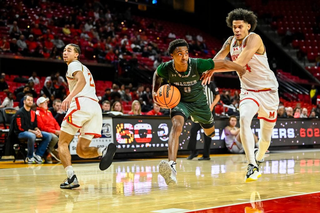 Dec 2, 2025; College Park, Maryland, USA; Wagner Seahawks guard Nick Jones (0) cuts in-between Maryland Terrapins forward Aleks Alston (24) and guard Myles Rice (2) during the first half at Xfinity Center. Mandatory Credit: Tommy Gilligan-Imagn Images