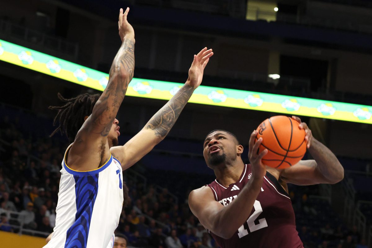 Dec 2, 2025; Pittsburgh, Pennsylvania, USA; Texas A&M Aggies forward Rashaun Agee (12) shoots against Pittsburgh Panthers forward Cameron Corhen (left) during the second half at the Petersen Events Center. Mandatory Credit: Charles LeClaire-Imagn Images