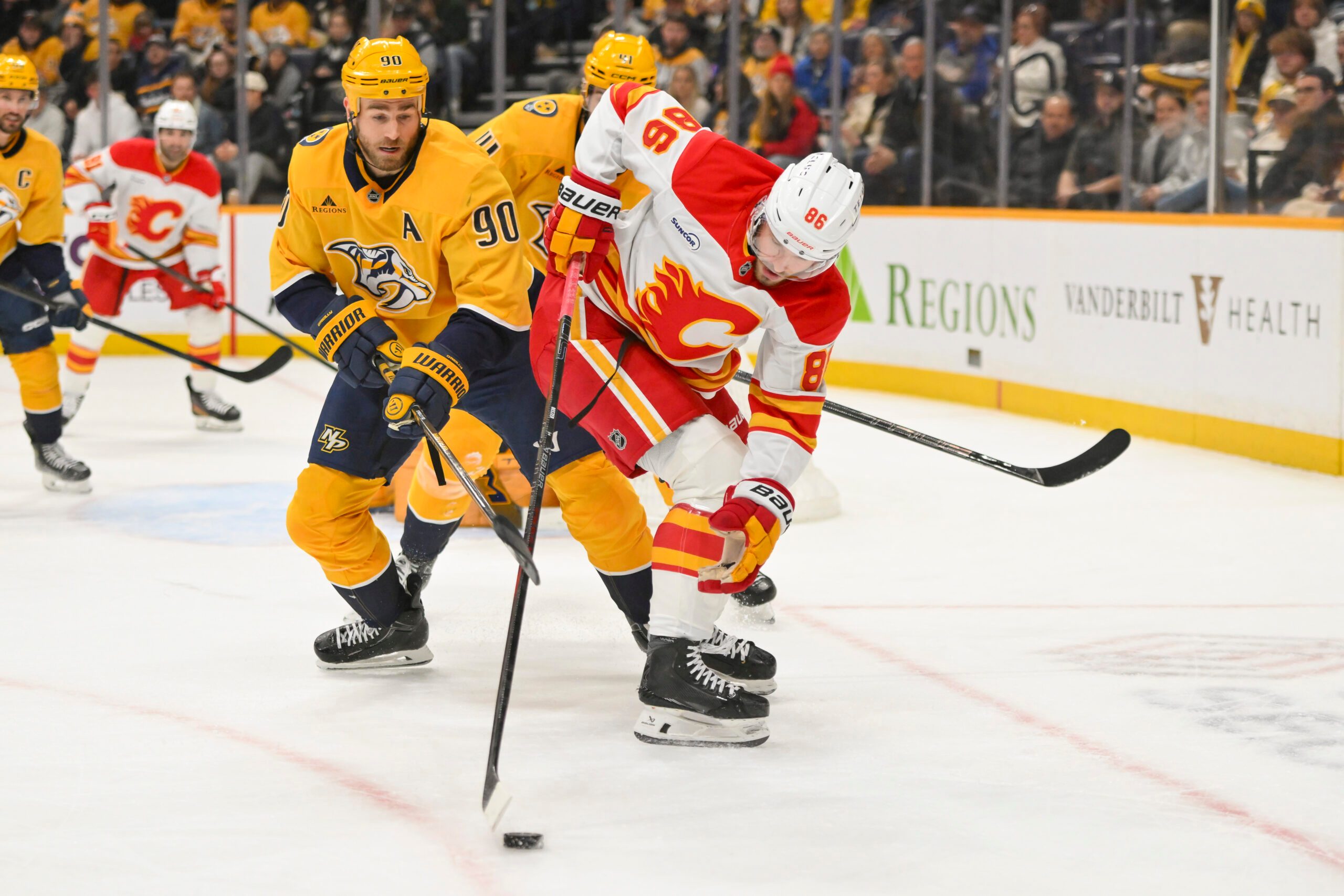 Dec 2, 2025; Nashville, Tennessee, USA;  Calgary Flames left wing Joel Farabee (86) and Nashville Predators center Ryan O'Reilly (90) battle for the puck during the second period at Bridgestone Arena. Mandatory Credit: Steve Roberts-Imagn Images
