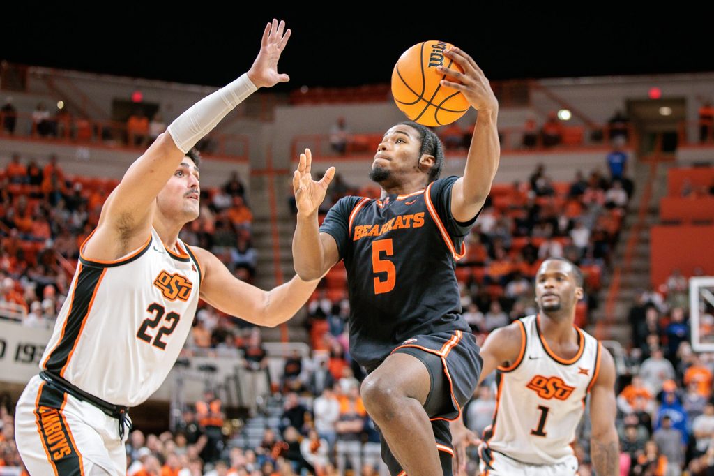Dec 2, 2025; Stillwater, Oklahoma, USA; Sam Houston Bearkats guard Justin Begg (5) drives to the basket around Oklahoma State Cowboys center Parsa Fallah (22) during the second half at Gallagher-Iba Arena. Mandatory Credit: William Purnell-Imagn Images