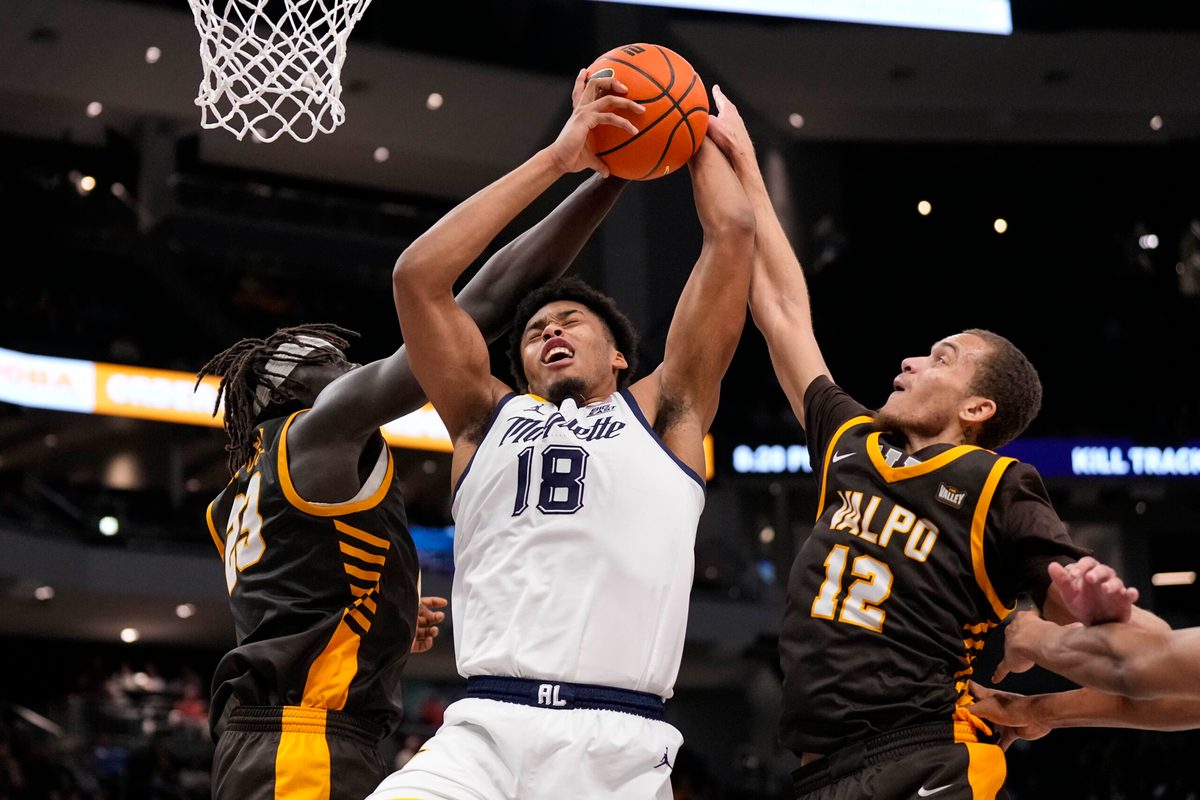 Dec 2, 2025; Milwaukee, Wisconsin, USA;  Marquette Golden Eagles forward Caedin Hamilton (18) grabs a rebound between Valparaiso Beacons center Shon Tupuola (23) and forward Owen Dease (12) during the second half at Fiserv Forum. Mandatory Credit: Jeff Hanisch-Imagn Images