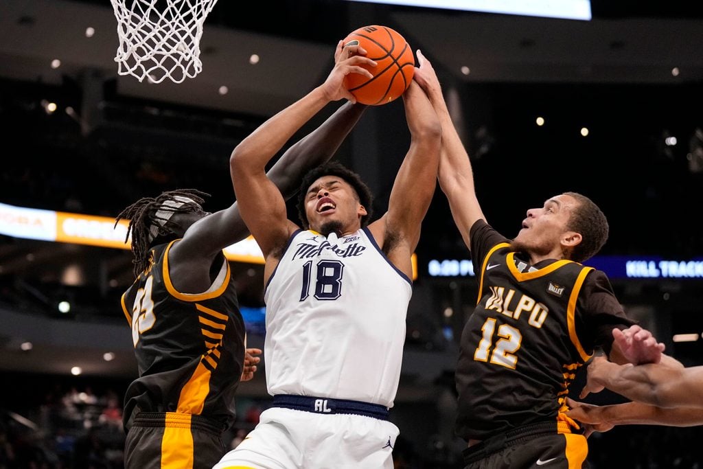 Dec 2, 2025; Milwaukee, Wisconsin, USA; Marquette Golden Eagles forward Caedin Hamilton (18) grabs a rebound between Valparaiso Beacons center Shon Tupuola (23) and forward Owen Dease (12) during the second half at Fiserv Forum. Mandatory Credit: Jeff Hanisch-Imagn Images