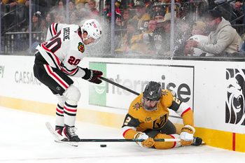 Dec 2, 2025; Las Vegas, Nevada, USA; Vegas Golden Knights defenseman Zach Whitecloud (2) crashes into the boards in front of Chicago Blackhawks center Ryan Greene (20) during the first period at T-Mobile Arena. Mandatory Credit: Stephen R. Sylvanie-Imagn Images