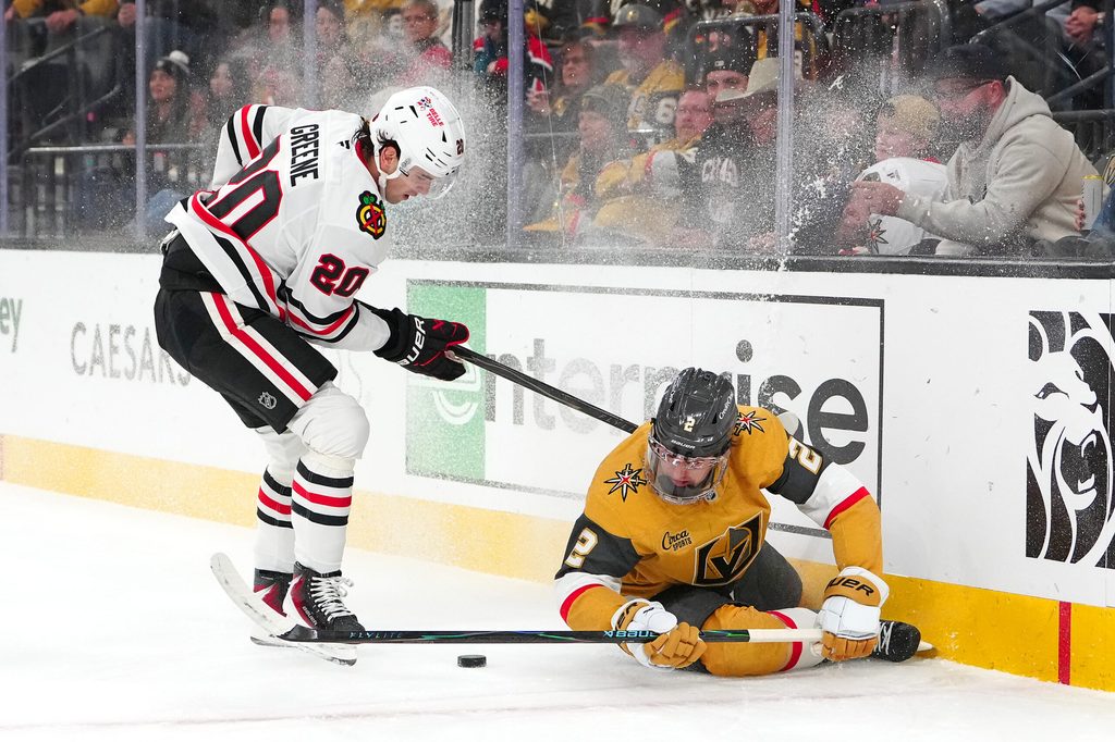 Dec 2, 2025; Las Vegas, Nevada, USA; Vegas Golden Knights defenseman Zach Whitecloud (2) crashes into the boards in front of Chicago Blackhawks center Ryan Greene (20) during the first period at T-Mobile Arena. Mandatory Credit: Stephen R. Sylvanie-Imagn Images