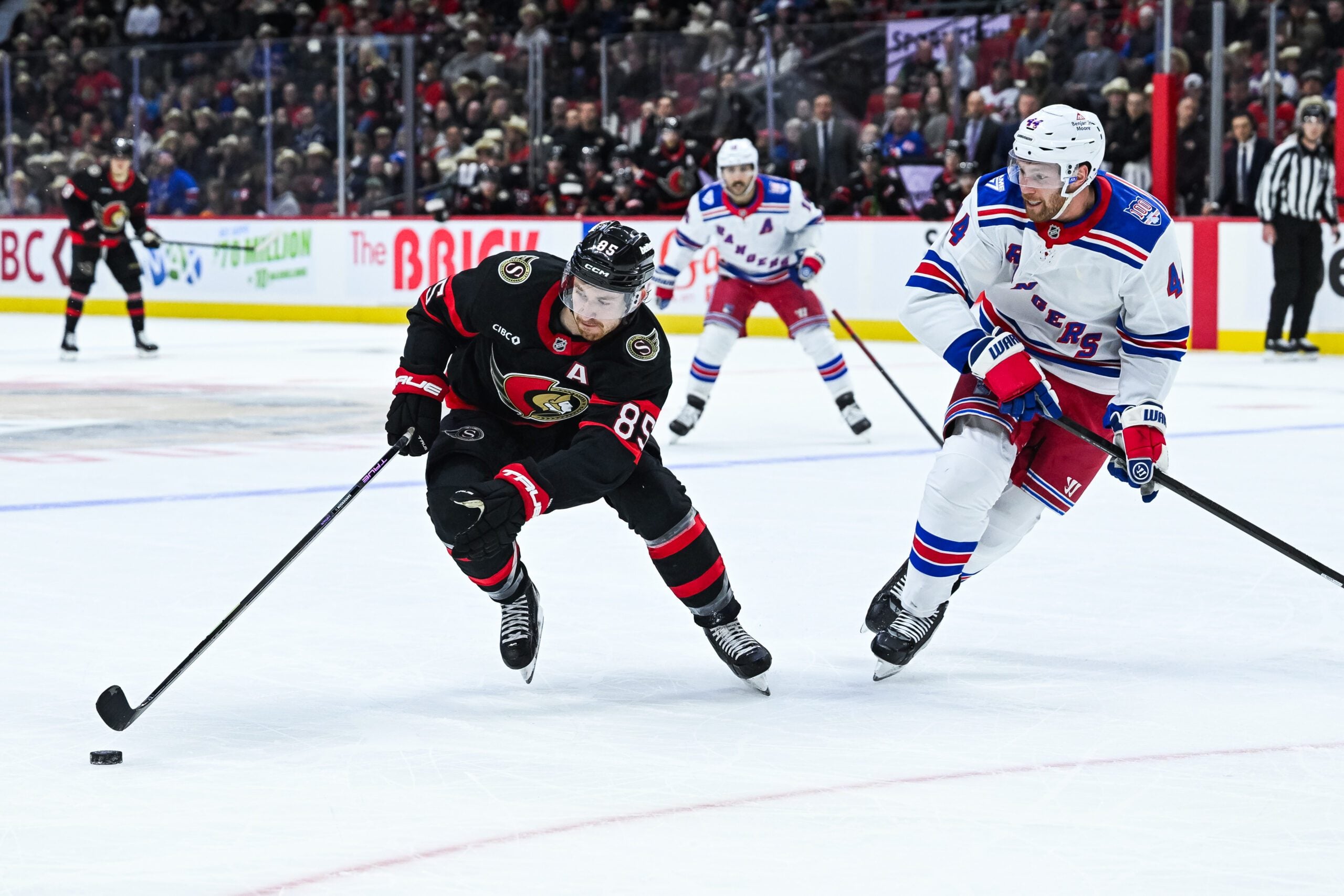 Dec 4, 2025; Ottawa, Ontario, CAN; Ottawa Senators center Lars Eller (89) plays the puck against New York Rangers defenseman Vladislav Gavrikov (44) during the first period at Canadian Tire Centre. Mandatory Credit: David Kirouac-Imagn Images