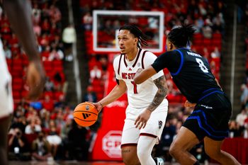 dDec 6, 2025; Raleigh, North Carolina, USA;  NC State Wolfpack forward Darrion Williams (1) dribbles the ball as UNC Asheville Bulldogs guard DJ Patrick (8) defends during the first half of the game at Lenovo Center. Mandatory Credit: Jaylynn Nash-Imagn Images
