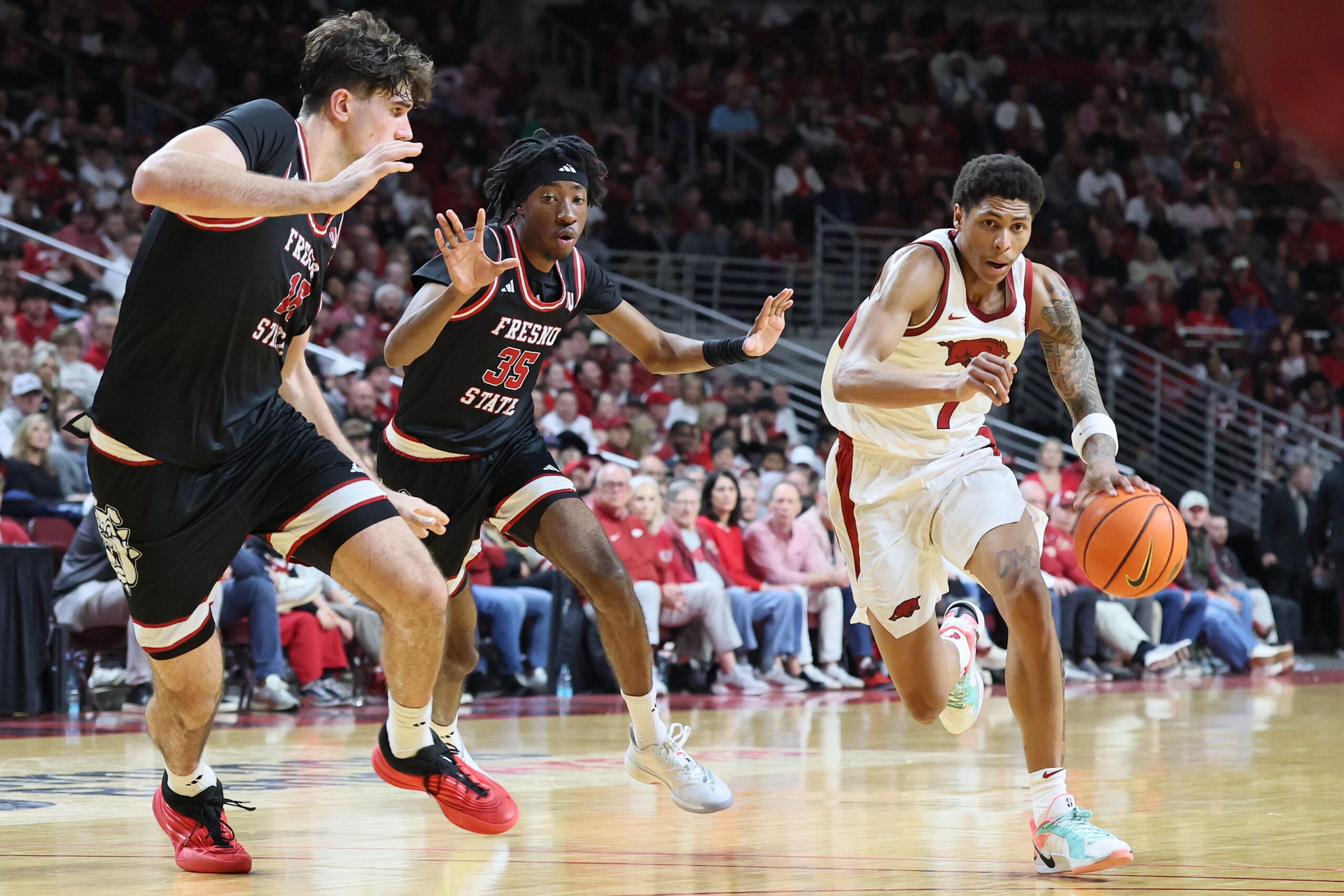 Dec 6, 2025; North Little Rock, Arkansas, USA; Arkansas Razorbacks guard Meleek Thomas (1) drives against Fresno State Bulldogs forwards Wilson Jacques (16) and DeShawn Gory (35) during the second half at Simmons Bank Arena. Arkansas won 82-58. Mandatory Credit: Nelson Chenault-Imagn Images