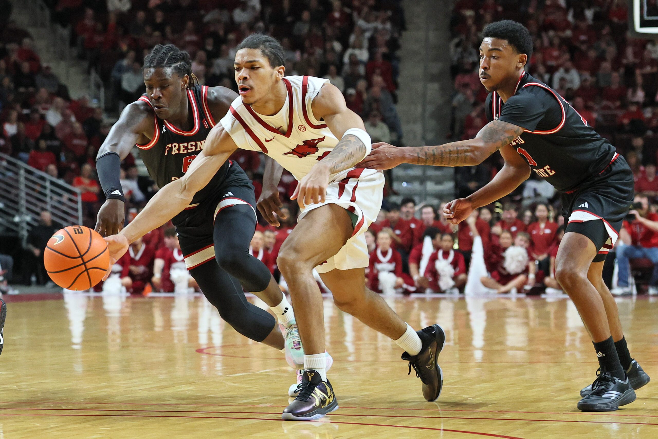 Dec 6, 2025; North Little Rock, Arkansas, USA; Arkansas Razorbacks guard Darius Acuff Jr (5) reaches for the ball between Fresno State Bulldogs guards DJ Stickman (6) and Zaon Collins (10) during the second half at Simmons Bank Arena. Arkansas won 82-58. Mandatory Credit: Nelson Chenault-Imagn Images