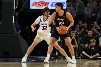 Dec 6, 2025; Phoenix, Arizona, USA;  Grand Canyon Lopes forward Wilhelm Breidenbach (32) plays defense on Oklahoma State Cowboys forward Parsa Fallah (22) at PHX Arena. Mandatory Credit: Anna Carrington-Imagn Images