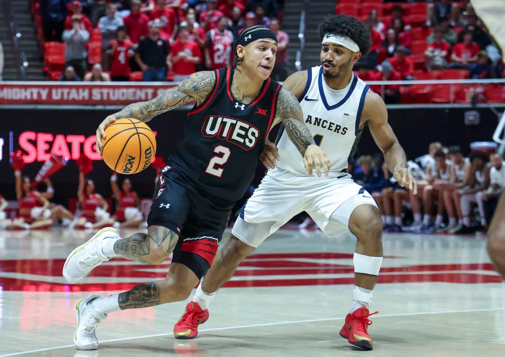 Dec 6, 2025; Salt Lake City, Utah, USA; Utah Utes guard Terrence Brown (2) dribbles the ball against California Baptist Lancers guard Dominique Daniels Jr. (1) during the second half at Jon M. Huntsman Center. Mandatory Credit: Rob Gray-Imagn Images