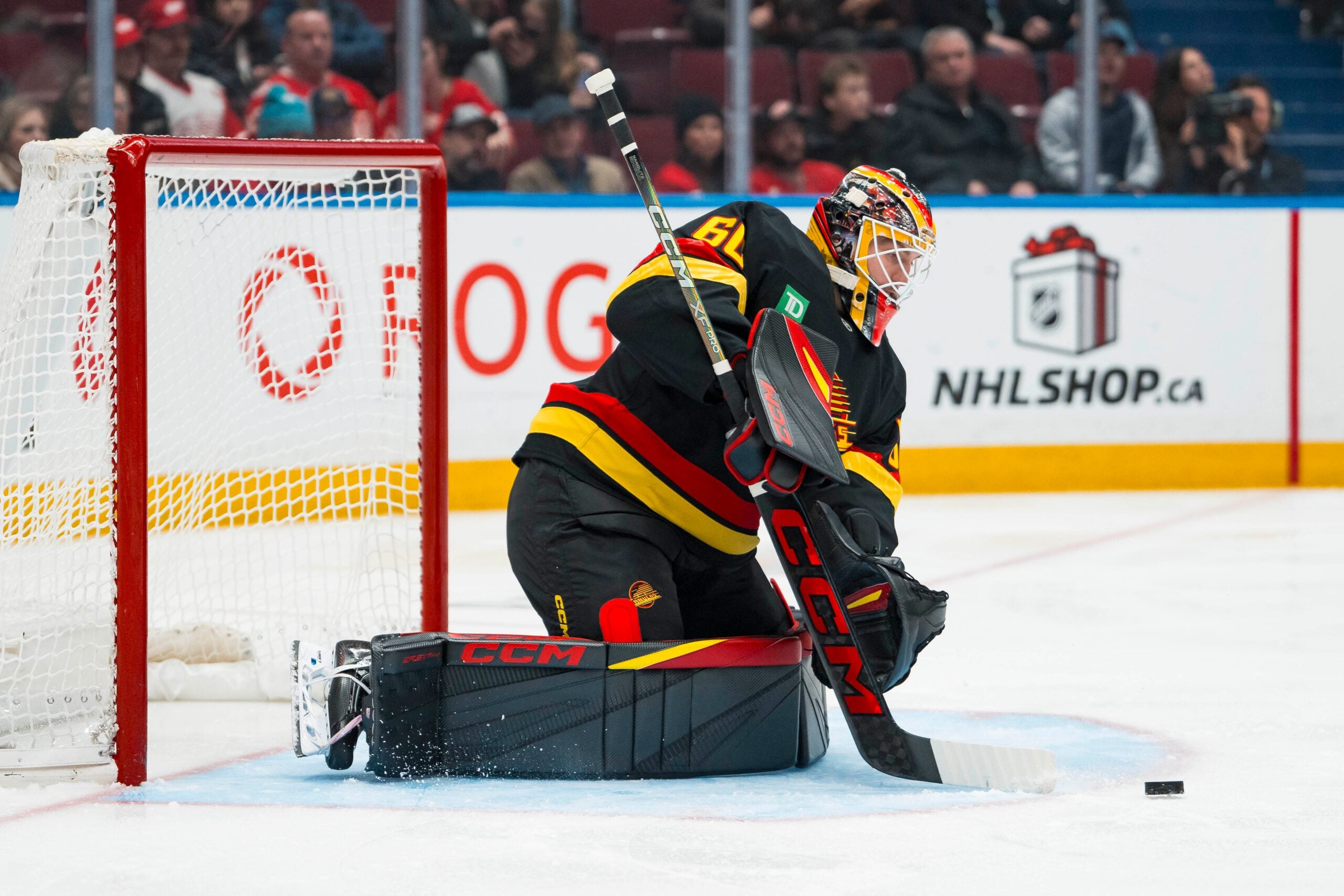 Dec 8, 2025; Vancouver, British Columbia, CAN; Vancouver Canucks goalie Nikita Tolopilo (60) makes a save against the Detroit Red Wings in the third period at Rogers Arena. Mandatory Credit: Bob Frid-Imagn Images