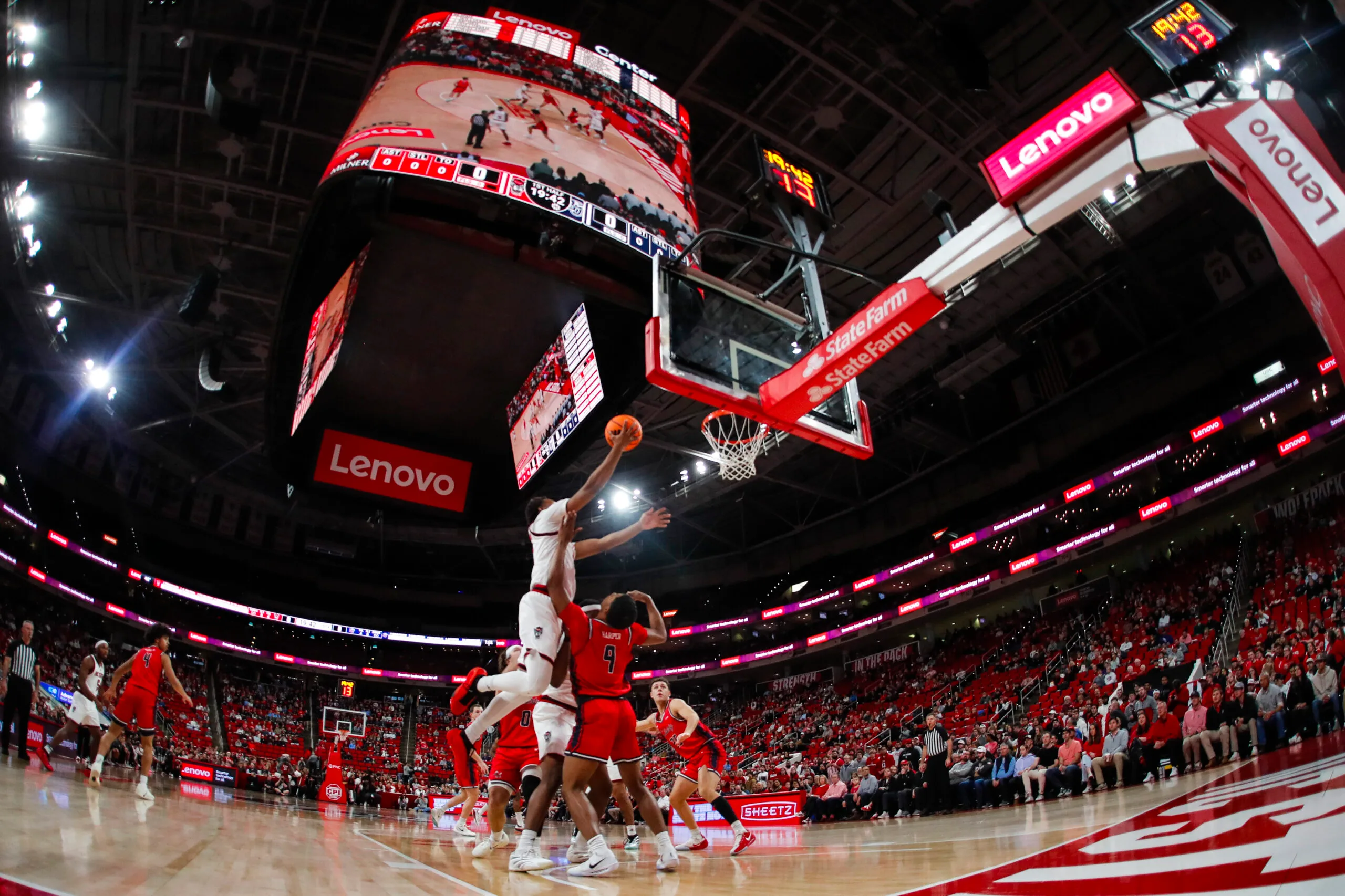 Dec 6, 2025; Raleigh, North Carolina, USA; NC State Wolfpack guard Quadir Copeland (11) dunks the ball past Liberty Flames guard JJ Harper (9) during the first half of the game at Lenovo Center. Mandatory Credit: Jaylynn Nash-Imagn Images