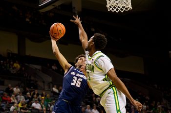 UC Davis guard Nils Cooper, left, goes up for a shot as Oregon forward Sean Stewart defends as the Oregon Ducks host the UC Davis Aggies on Dec. 13, 2025, at Matthew Knight Arena in Eugene, Oregon.