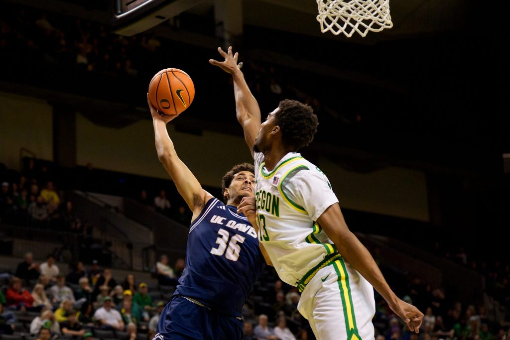 UC Davis guard Nils Cooper, left, goes up for a shot as Oregon forward Sean Stewart defends as the Oregon Ducks host the UC Davis Aggies on Dec. 13, 2025, at Matthew Knight Arena in Eugene, Oregon.