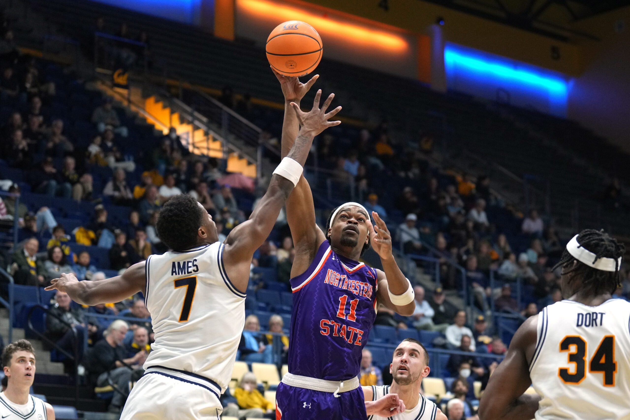 Dec 13, 2025; Berkeley, California, USA; Northwestern State Demons guard Chris Mubiru (11) shoots against California Golden Bears guard Dai Dai Ames (7) during the second half at Haas Pavilion. Mandatory Credit: Darren Yamashita-Imagn Images