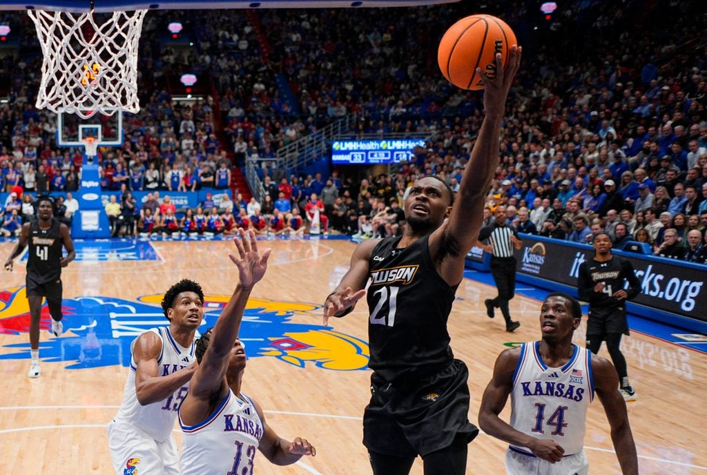 Dec 16, 2025; Lawrence, Kansas, USA; Towson Tigers guard Jack Doumbia Jr. (21) shoots against the Kansas Jayhawks during the first half at Allen Fieldhouse. Mandatory Credit: Jay Biggerstaff-Imagn Images