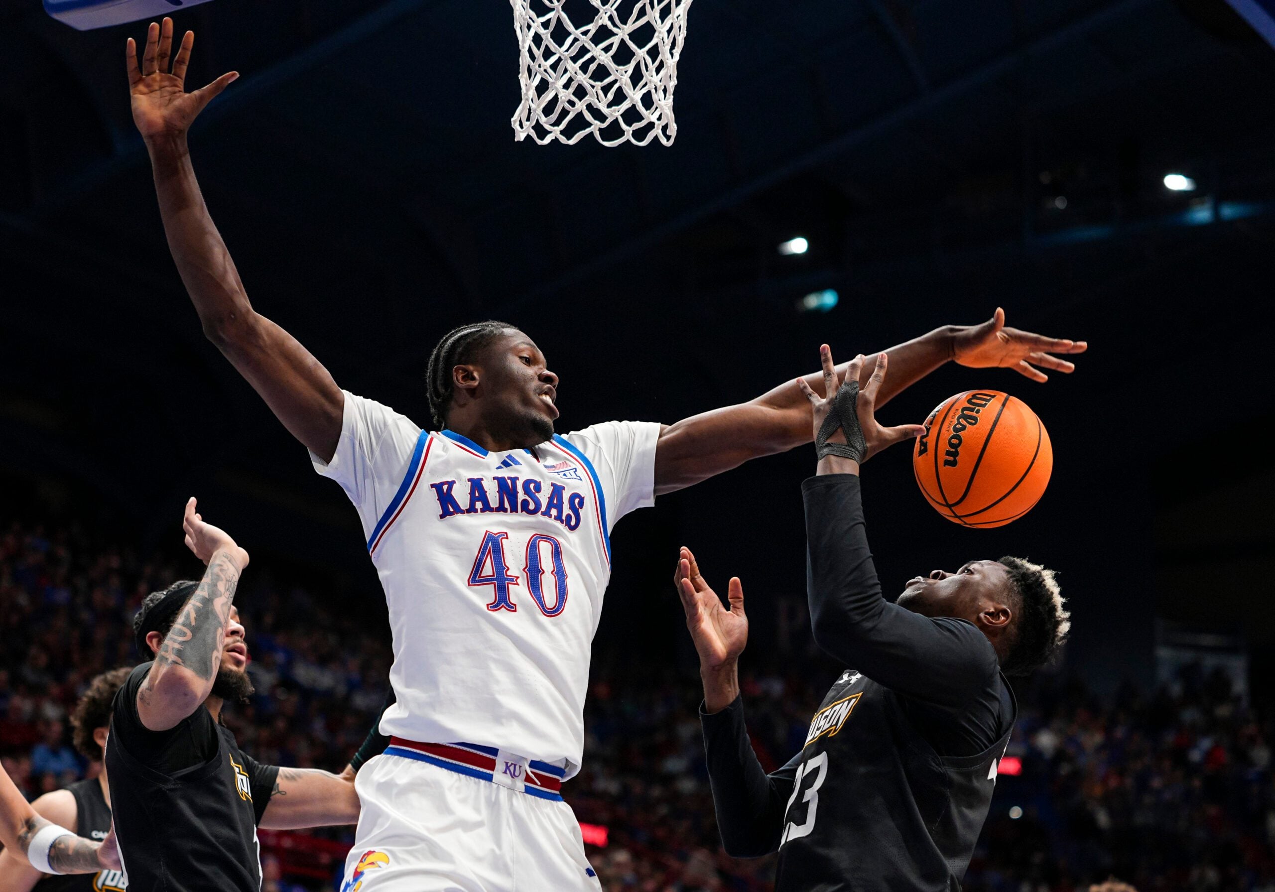 Dec 16, 2025; Lawrence, Kansas, USA; Kansas Jayhawks forward Flory Bidunga (40) and Towson Tigers forward Caleb Embeya (23) fight for a rebound during the second half at Allen Fieldhouse. Mandatory Credit: Jay Biggerstaff-Imagn Images