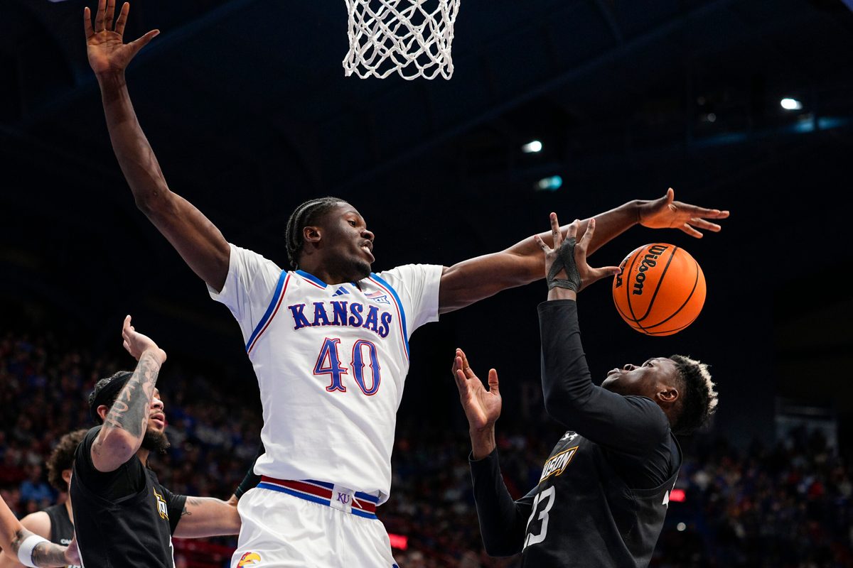 Dec 16, 2025; Lawrence, Kansas, USA; Kansas Jayhawks forward Flory Bidunga (40) and Towson Tigers forward Caleb Embeya (23) fight for a rebound during the second half at Allen Fieldhouse. Mandatory Credit: Jay Biggerstaff-Imagn Images