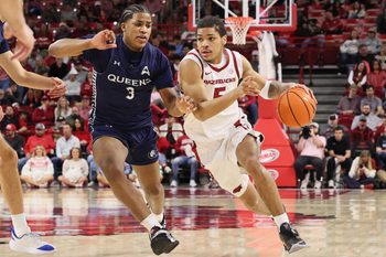 Dec 16, 2025; Fayetteville, Arkansas, USA; Arkansas Razorbacks guard Darius Acuff Jr (5) drives against Queens Royals Isaiah Henry (3) during the second half at Bud Walton Arena. Arkansas won 108-80. Mandatory Credit: Nelson Chenault-Imagn Images