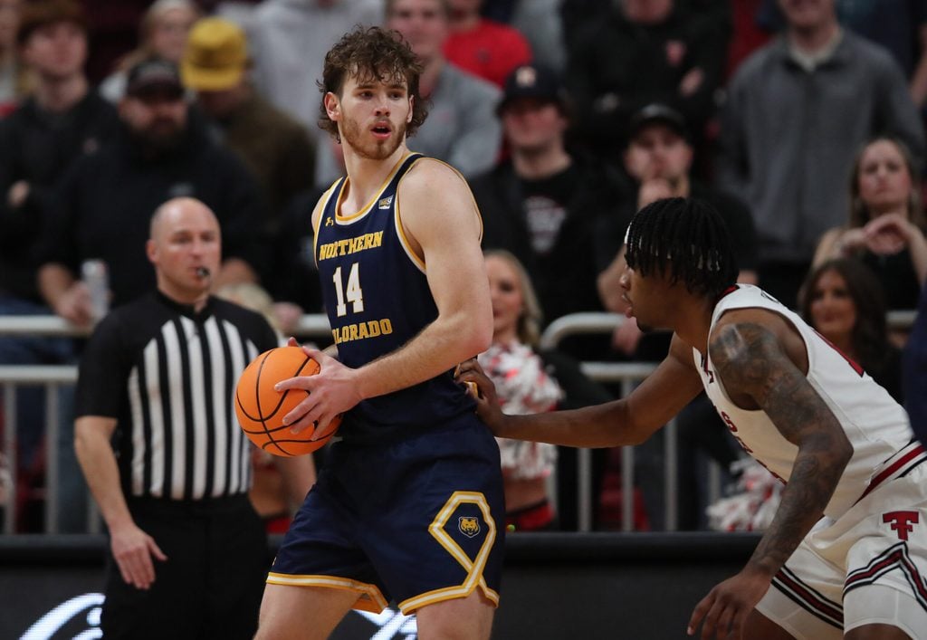 Dec 16, 2025; Lubbock, Texas, USA; Northern Colorado Bears forward Brock Wisne (14) holds the ball in front of Texas Tech Red Raiders forward JT Toppin (15) in the second half at United Supermarkets Arena. Mandatory Credit: Michael C. Johnson-Imagn Images