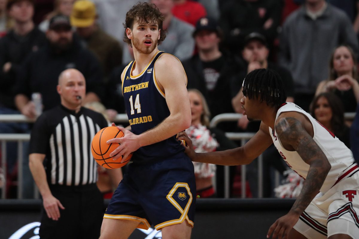Dec 16, 2025; Lubbock, Texas, USA; Northern Colorado Bears forward Brock Wisne (14) holds the ball in front of Texas Tech Red Raiders forward JT Toppin (15) in the second half at United Supermarkets Arena. Mandatory Credit: Michael C. Johnson-Imagn Images