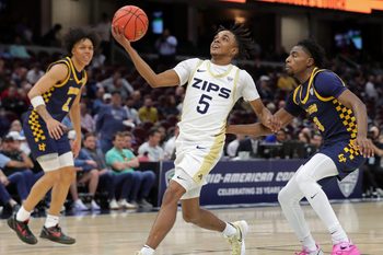 Akron Zips guard Tavari Johnson goes to the basket ahead of Toledo guard Sonny Wilson in the first half of a Mid-American Conference Tournament semifinal, Friday, March 14, 2025, in Cleveland.